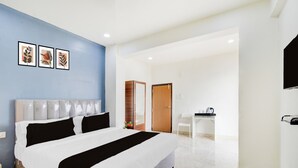 Quarto de hotel com cama, escrivaninha e cadeira.