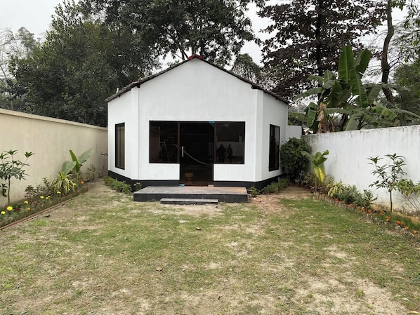 A small, single-story building with a flat roof, a front door, and a small porch area.