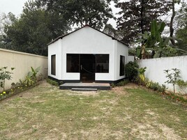 Um pequeno edifício térreo com telhado plano, porta frontal e pequeno alpendre.