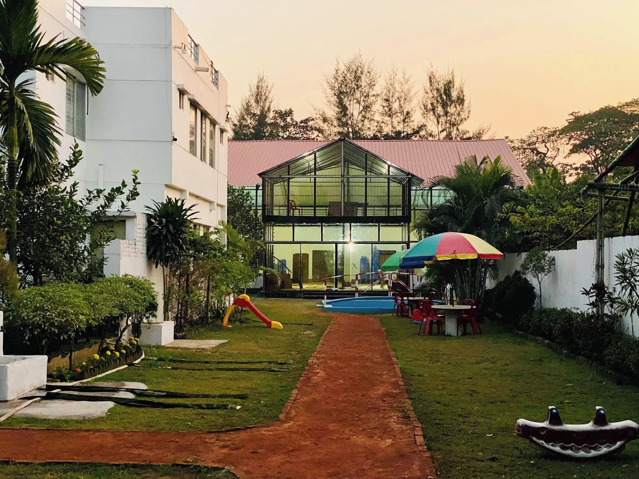 Un edificio moderno con fachada de vidrio, piscina y mobiliario exterior.