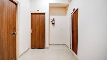 Un pasillo con puertas de madera, con los números 301 y 302, y un extintor de incendios sujeto a la pared.