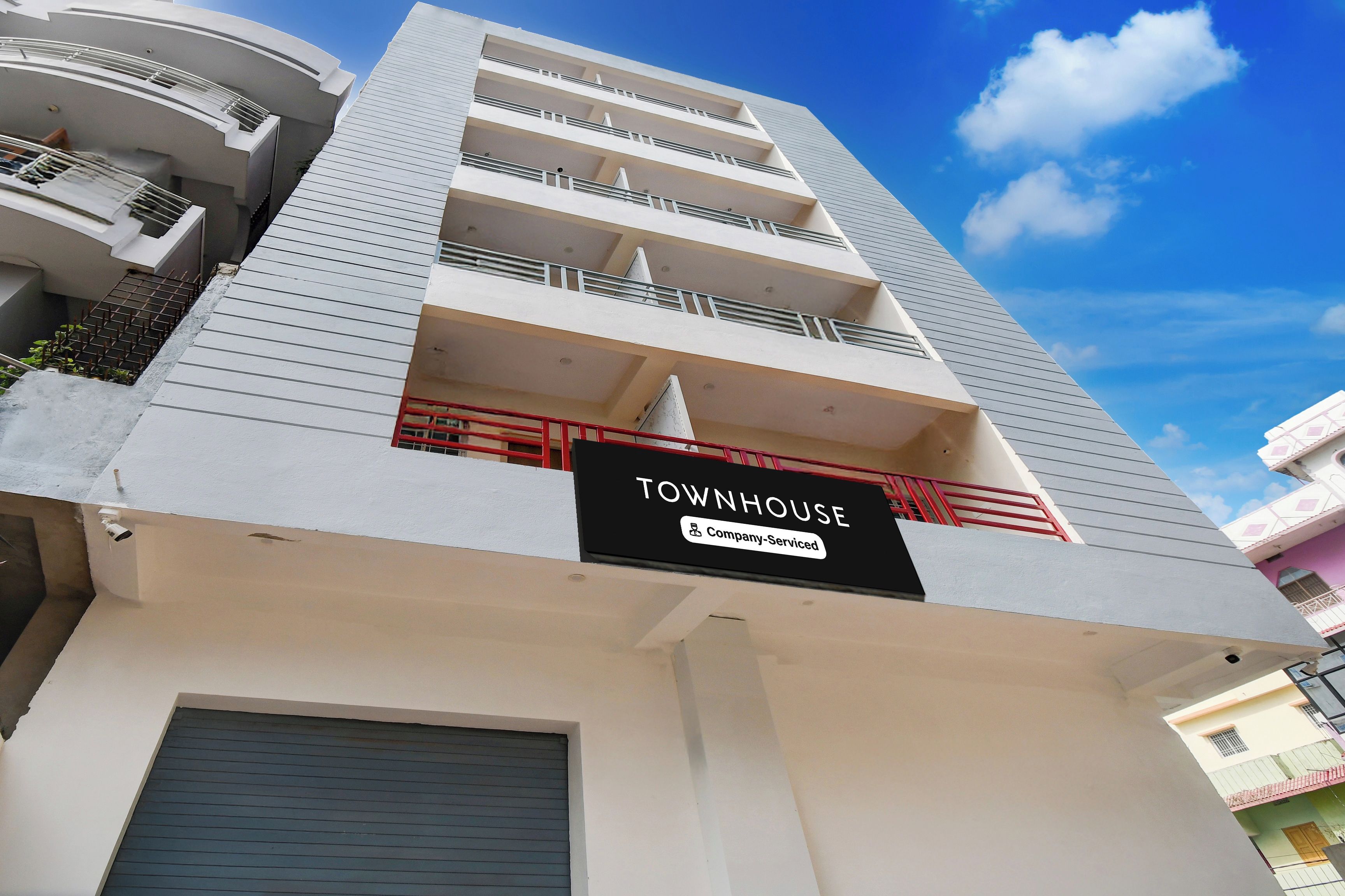 Un edificio de varios pisos con un letrero que indica que se trata de una casa townhouse con servicios de empresa.