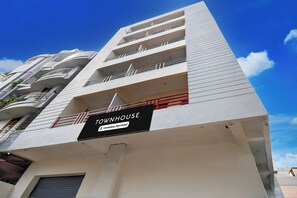 Un edificio de varios pisos con un letrero que indica 'TOWNHOUSE Company-Serviced'.