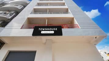 Un edificio de varios pisos con un letrero que dice 'TOWNHOUSE' y 'Company-Serviced'.