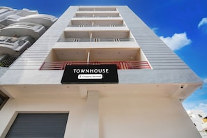 Un edificio de varios pisos con un letrero que dice 'TOWNHOUSE' y 'Company-Serviced'.