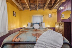A bedroom with a bed, a wooden dresser, and a ceiling with exposed beams. - Unique Pet-Friendly Stay | Near Downtown Denver (Denver)