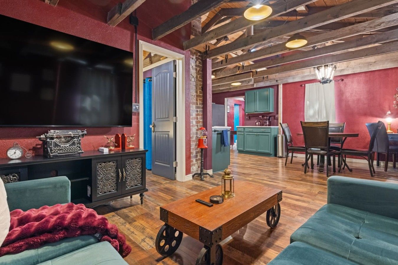 A living room with a television, a wooden coffee table, and a dining area with chairs and a table.