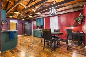 A kitchen with wooden beams, a refrigerator, and a dining area with chairs and a table. - Unique Pet-Friendly Stay | Near Downtown Denver (Denver)