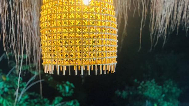 A hanging lamp with a geometric pattern, a staircase, and greenery. - Dreamville (Ballaketuwa)