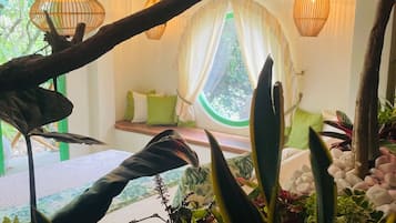 Una habitación con una cama, una ventana con cortinas y luces colgantes.