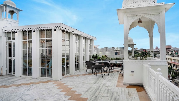 A rooftop terrace with a seating area, a white gazebo, and a view of the cityscape. - Townhouse Oak Durgapura Railway Junction (Jaipur)