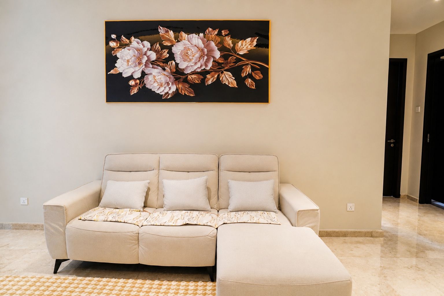 A living room with a beige sofa, a patterned throw, and a large floral artwork on the wall.