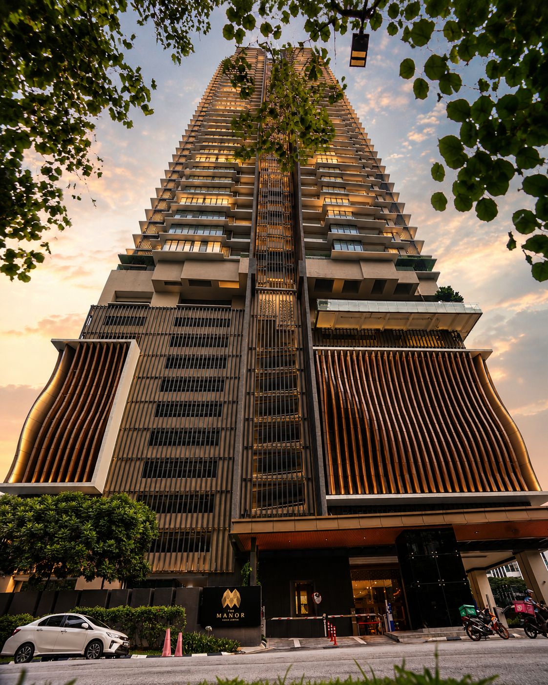 A high-rise hotel with a modern design, featuring a prominent vertical structure and a well-lit entrance.