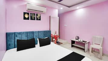 Un dormitorio moderno con una cama grande, cabecera azul, aire acondicionado y ventilador de techo.