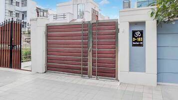 A gated residential area with a closed metal gate and a sign indicating a sector number.