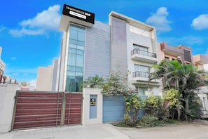 A modern building with a sign indicating it is a company-serviced townhouse. - Townhouse Oak Sector 51 Noida (Noida)