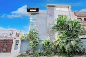 A modern building with a sign indicating it is company-serviced. - Townhouse Oak Sector 51 Noida (Noida)
