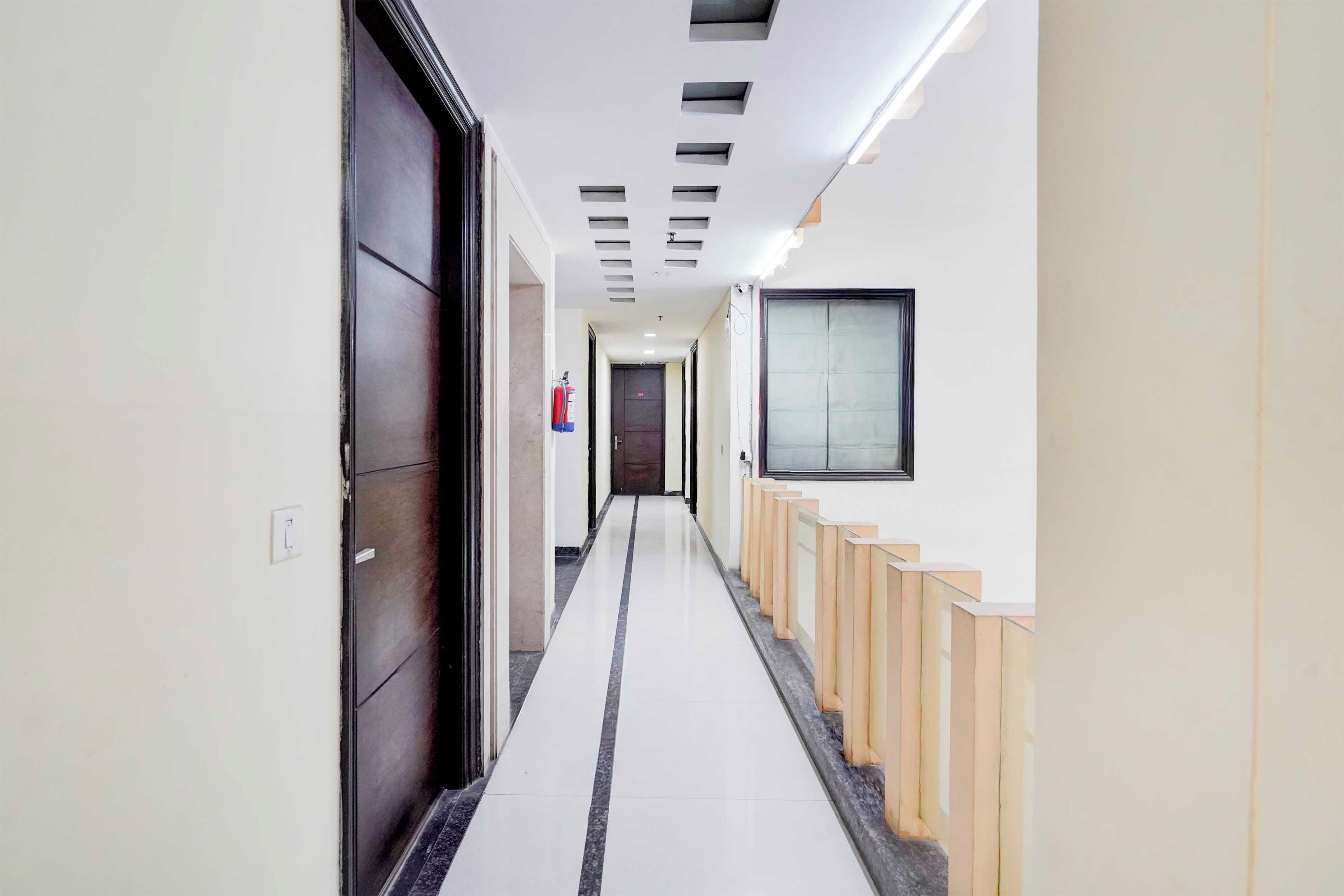 A corridor with a fire extinguisher, a door, and a window.