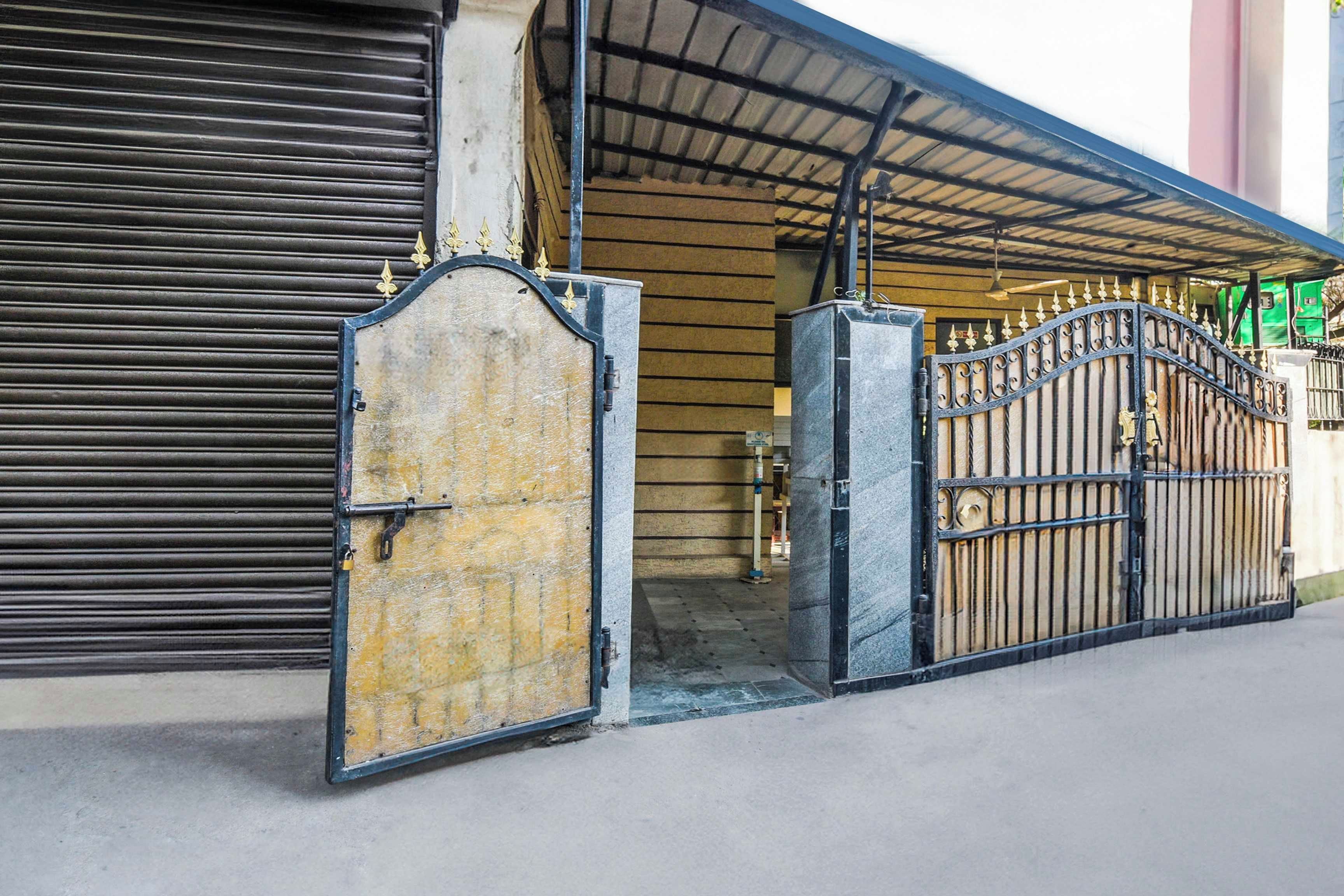 Una entrada protegida con un portón metálico y un toldo enrollable.
