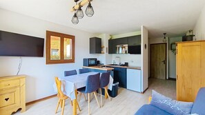 A compact living space with a dining area, kitchenette, and a small seating area. - Joran JR1 MOUNTAIN & NATURE (4 people) (Châtel)