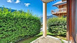 A wooden building with a balcony, surrounded by lush green hedges and a clear blue sky. - Joran JR1 MOUNTAIN & NATURE (4 people) (Châtel)