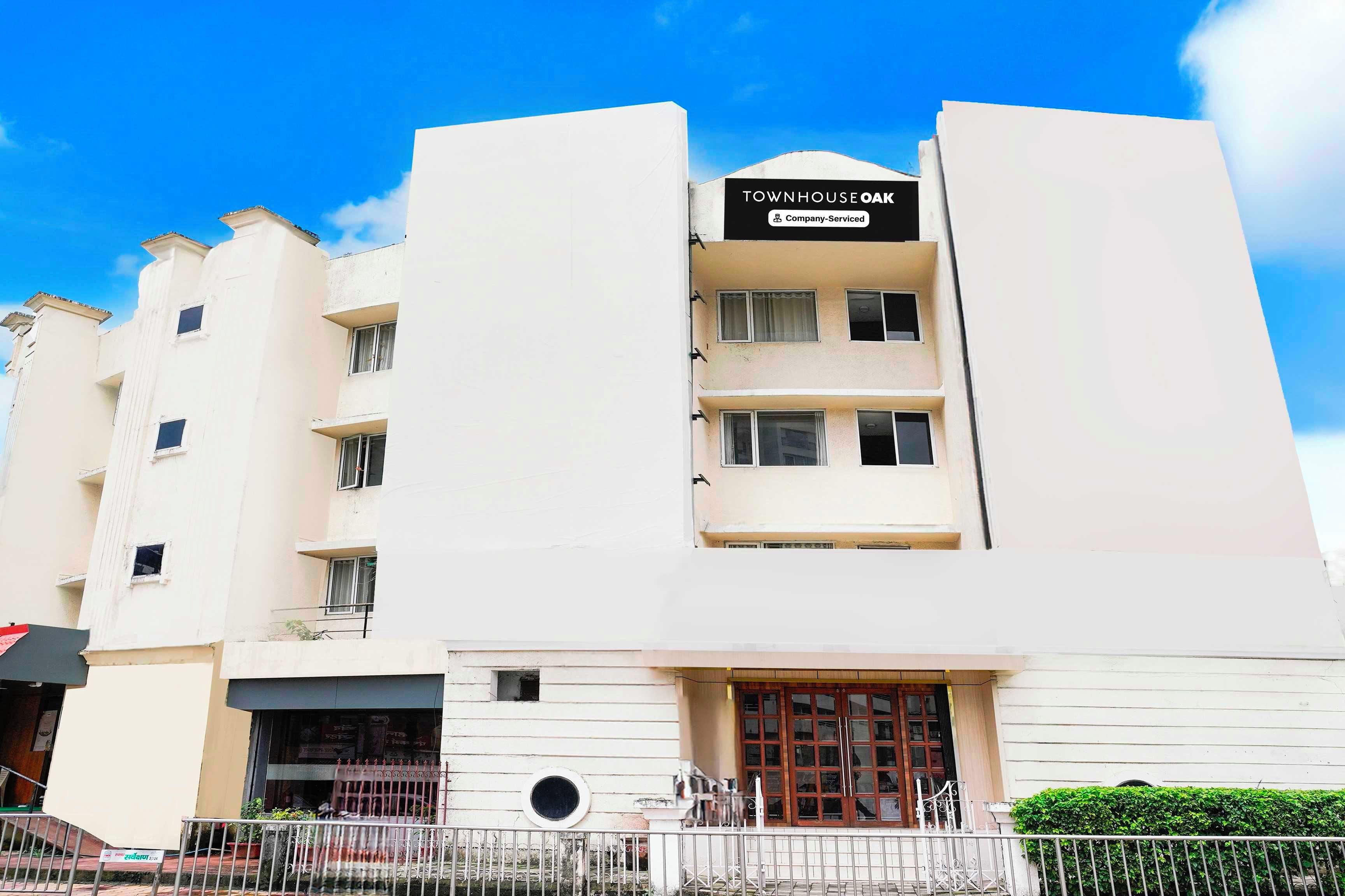 A multi-story building with a sign indicating it is company-serviced.