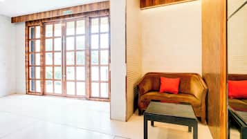 A reception area with a wooden bench, a small table, and a large glass door with multiple windows.