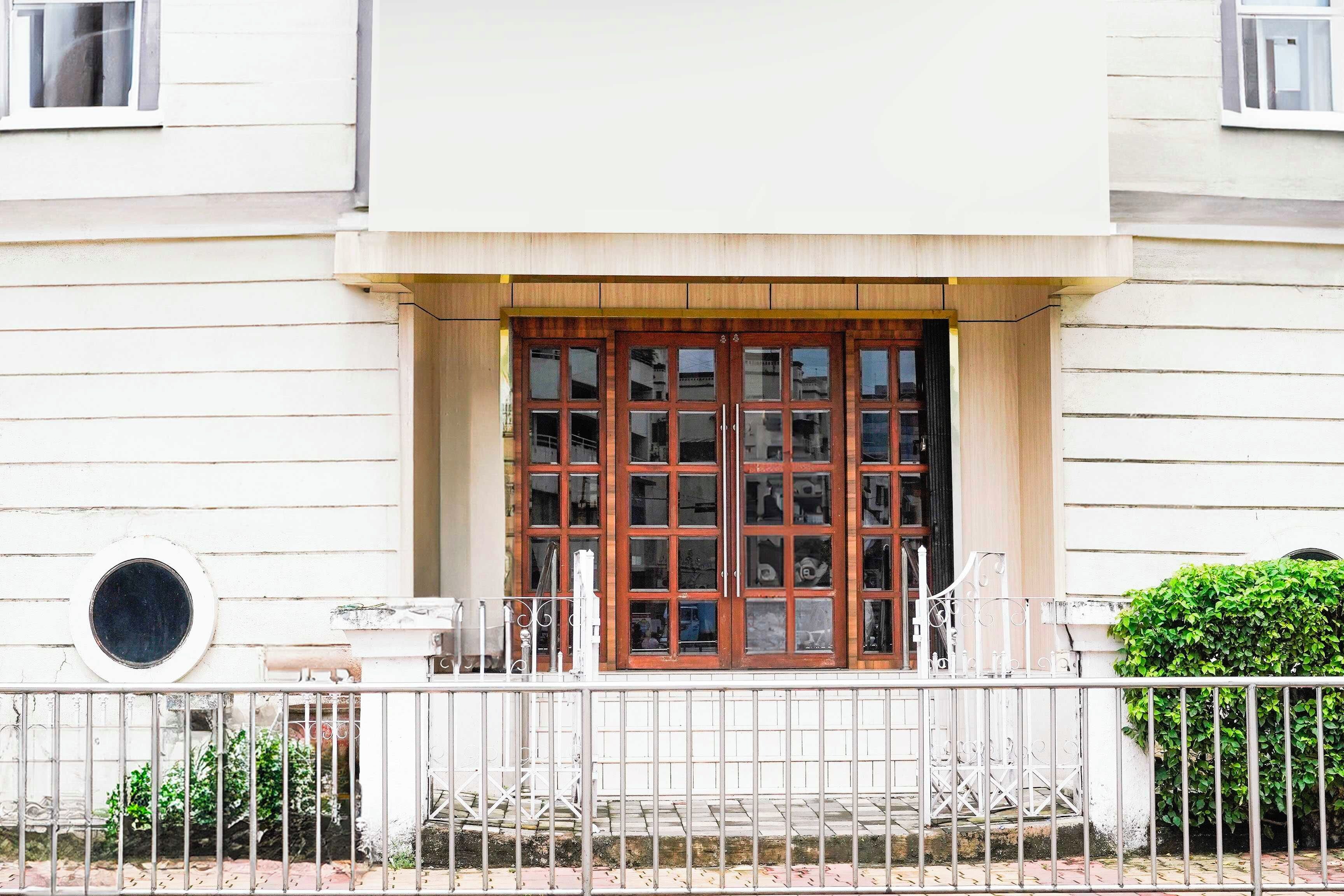 Un edificio con una puerta de madera grande y varias ventanas.