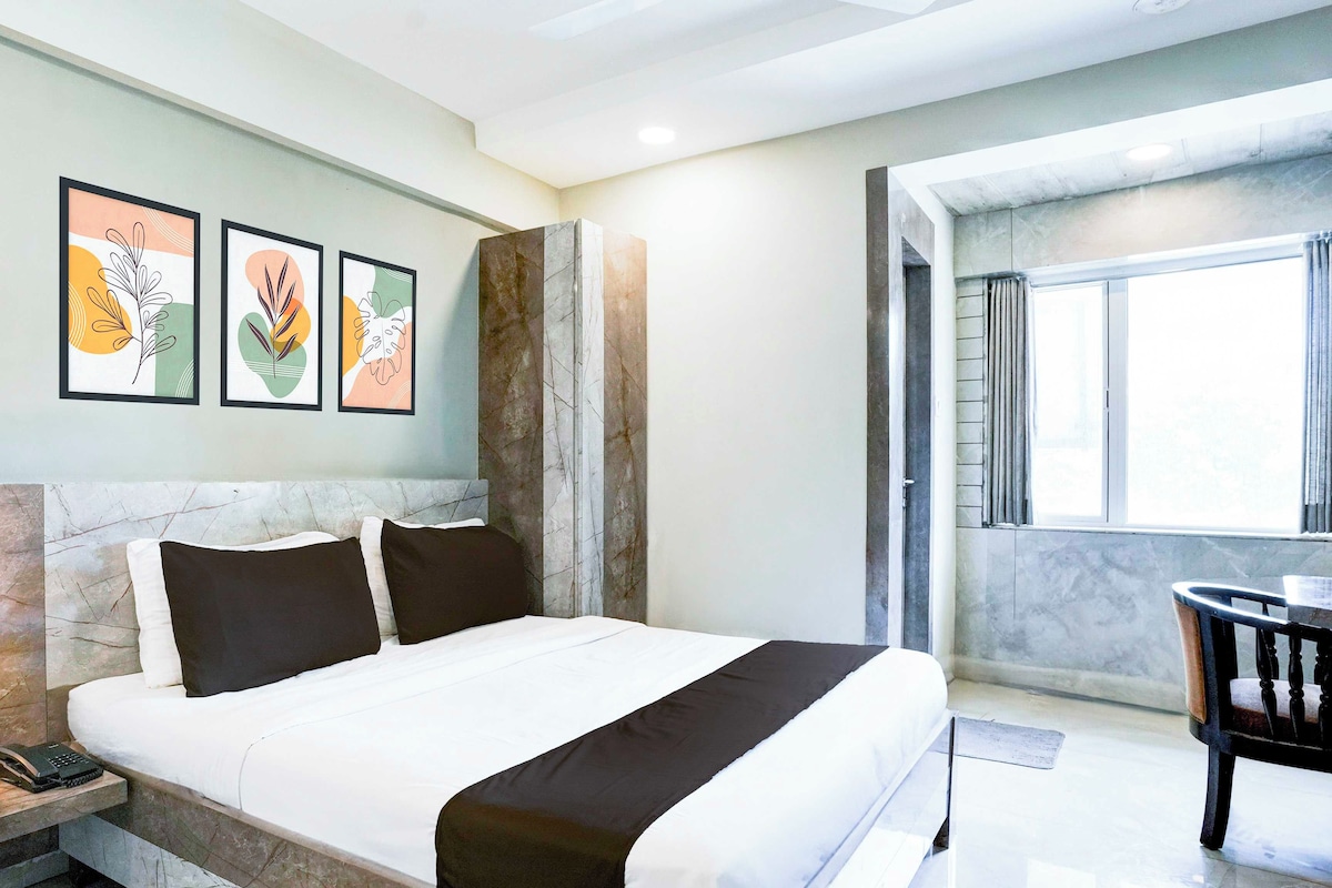 Una habitación de hotel con cama, escritorio y ventana.