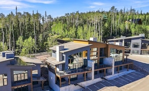 See the full beauty of the home, surrounded by towering trees and incredible mountain views.