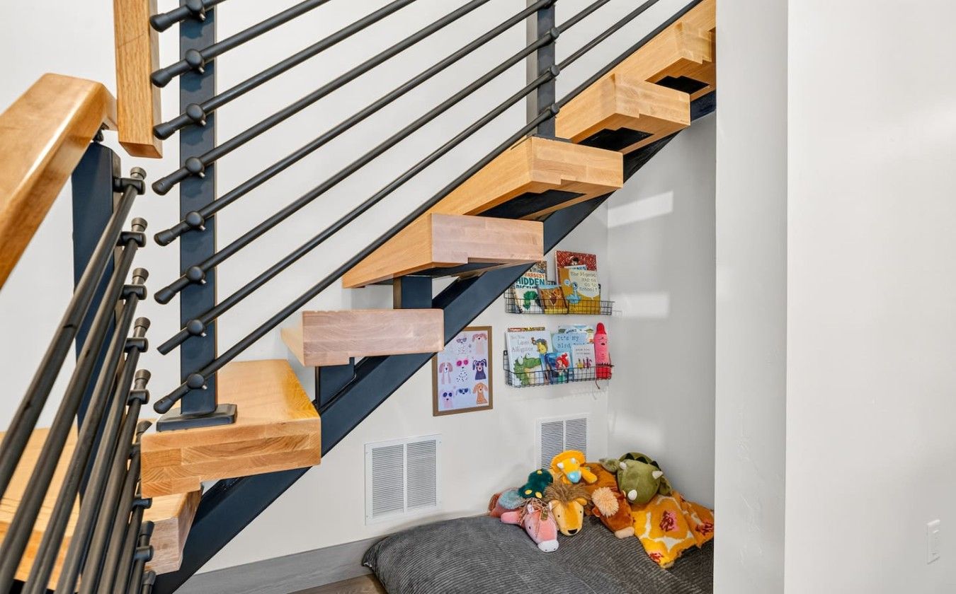 A playful space beneath the staircase gives younger guests a cozy spot to relax and enjoy the home`s family-friendly touches.