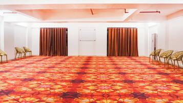 A conference room with a patterned carpet, white walls, and curtains.