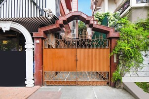 A gated entrance with a decorative metal gate and a white column.