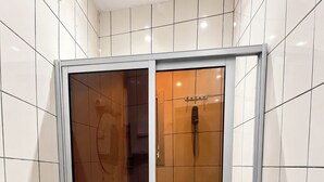 Un baño con inodoro, bidé y cabina de ducha.