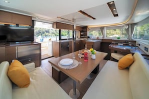 Ein modernes Wohnmobil-Interieur mit Essbereich, Küchenzeile und Sitzgelegenheiten.
