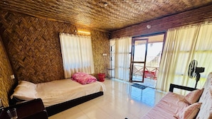 A room with a bed, a sofa, a fan, and a window with curtains. - Ratnodwip Beach View Resort (Cox's Bazar)