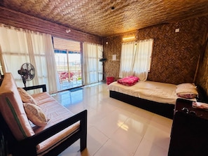 A room with a bed, a sofa, a fan, and a window with curtains. - Ratnodwip Beach View Resort (Saint Martin's Island)