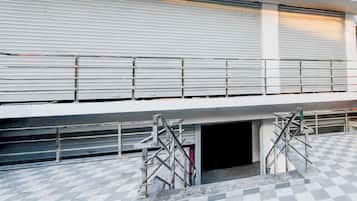 A building with a closed shuttered entrance, metal scaffolding, and a checkered floor pattern.