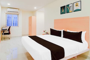 Una habitación de hotel con cama, escritorio y ventana.