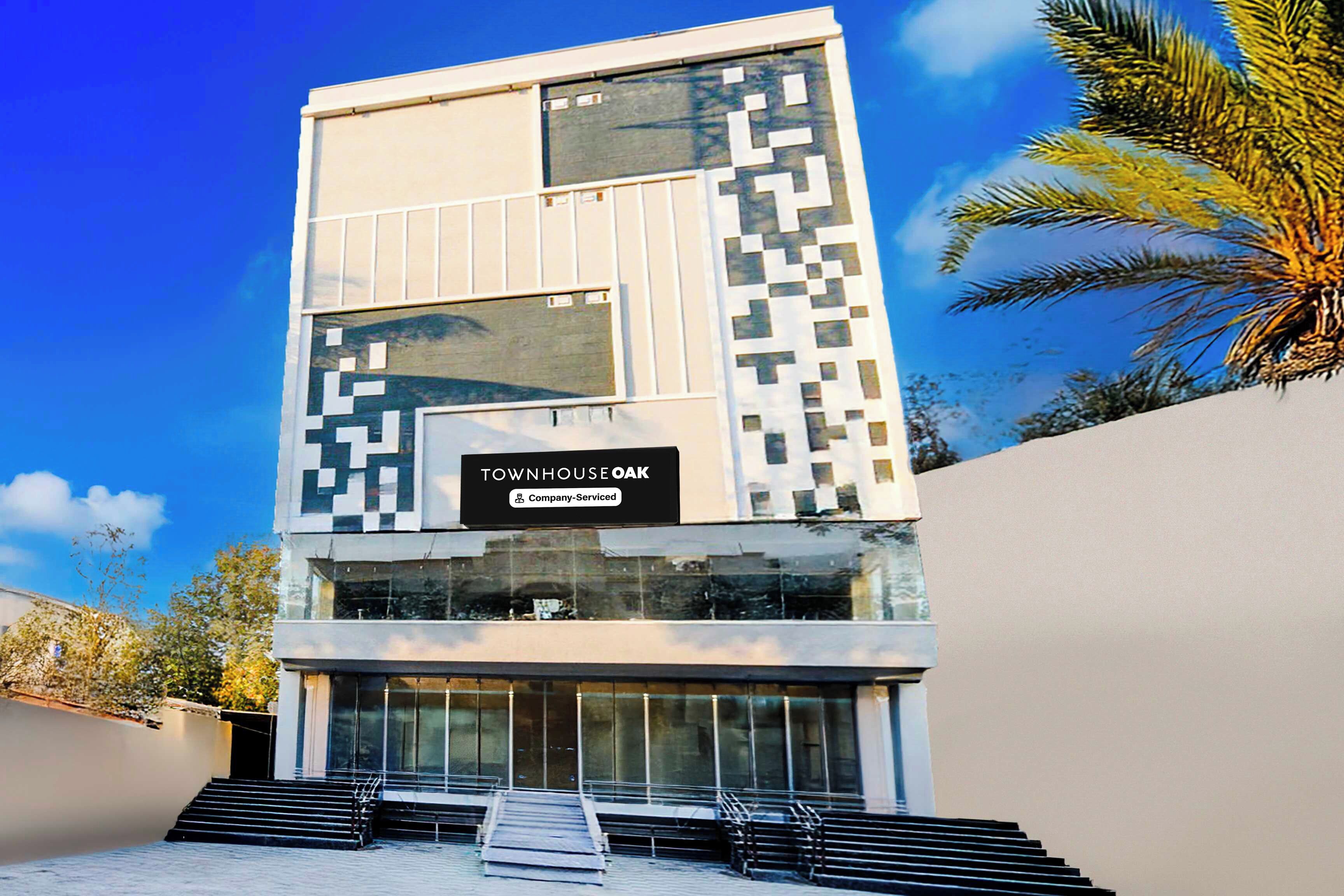 A modern building with a sign reading 'TOWNHOUSE OAK Company-Serviced.'