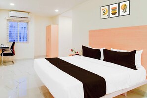 Una habitación de hotel con una cama, un escritorio y una ventana.