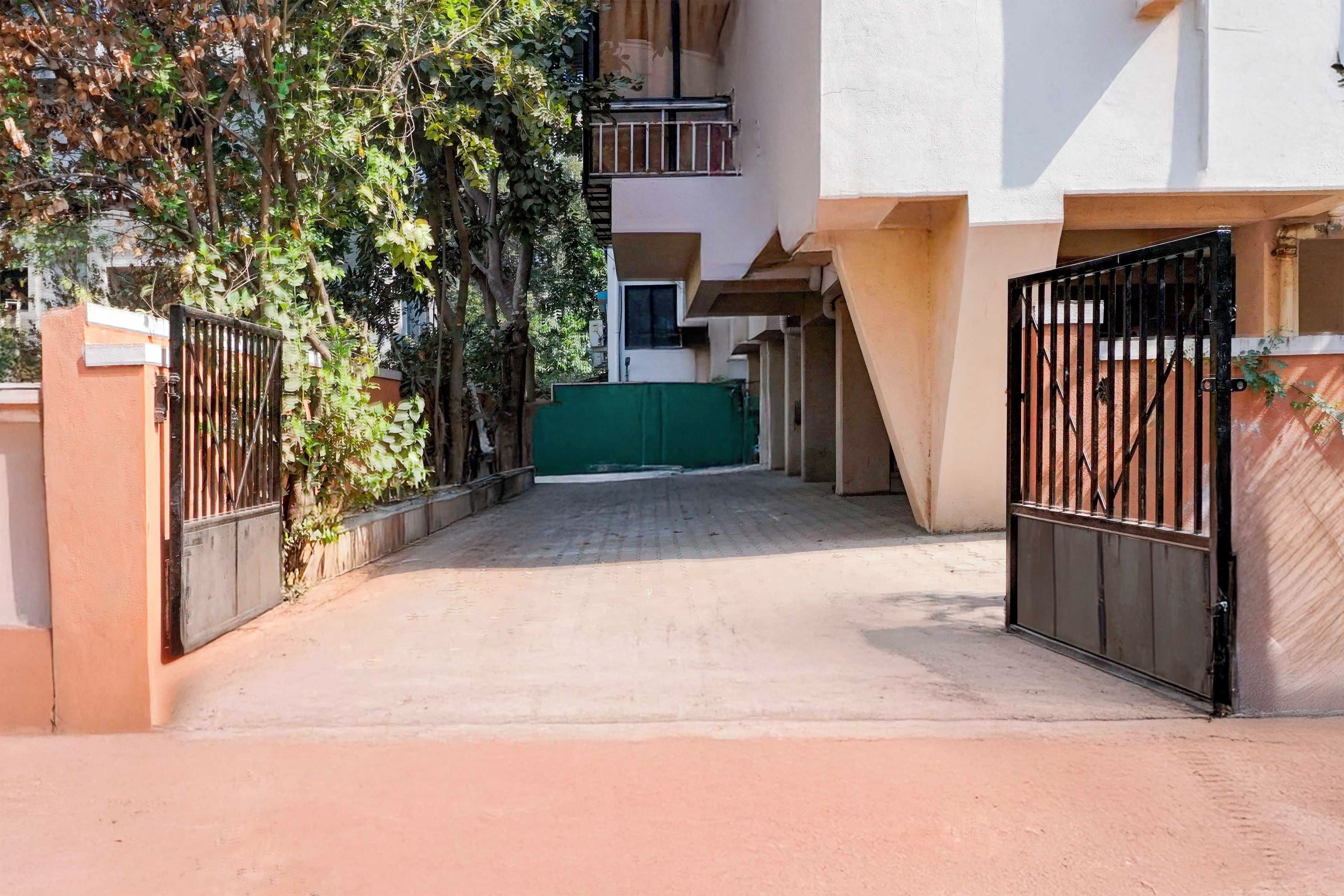 Una entrada con portón a una zona residencial, con un sendero pavimentado que lleva a un edificio.