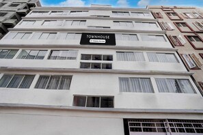 Um edifício de vários andares com uma placa que diz 'TOWNHOUSE Company-Serviced'.