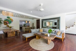 A modern living room with a wooden coffee table, a sofa, and a dining table with chairs. - 4 bedroom villa in Canggu, 2 minutes walk to the beach (canggu)