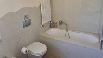 Un bagno con vasca, WC, bidet e lavandino.