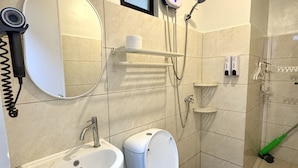 Moderni kylpyhuone, jossa on wc, pesuallas ja suihku.