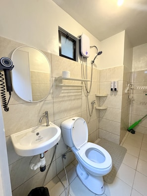 A modern bathroom with a toilet, sink, and shower. - Royal Oceancrest Panglao 1 (Dauis)