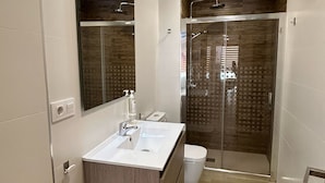 Ein modernes Badezimmer mit Waschbecken, Spiegel und Dusche.