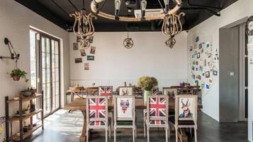 Una zona de dinar amb un lampadari, mobles de fusta i decoracions murals.