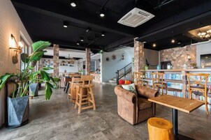 Un espacio interior con zonas de estar, un bar y una escalera.